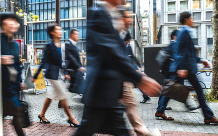 一群模糊的商务人士在日本的街道上通勤